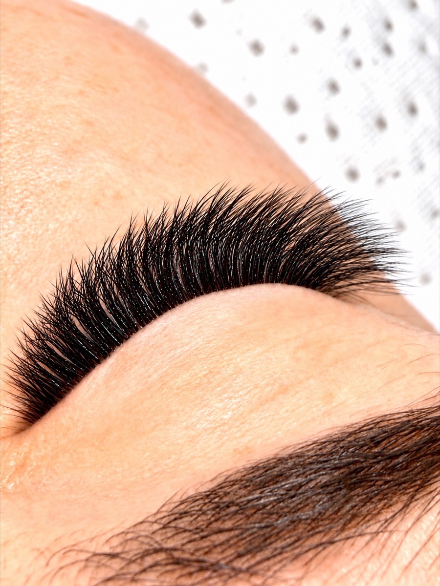 Close-up of finished lash extensions on a closed eye